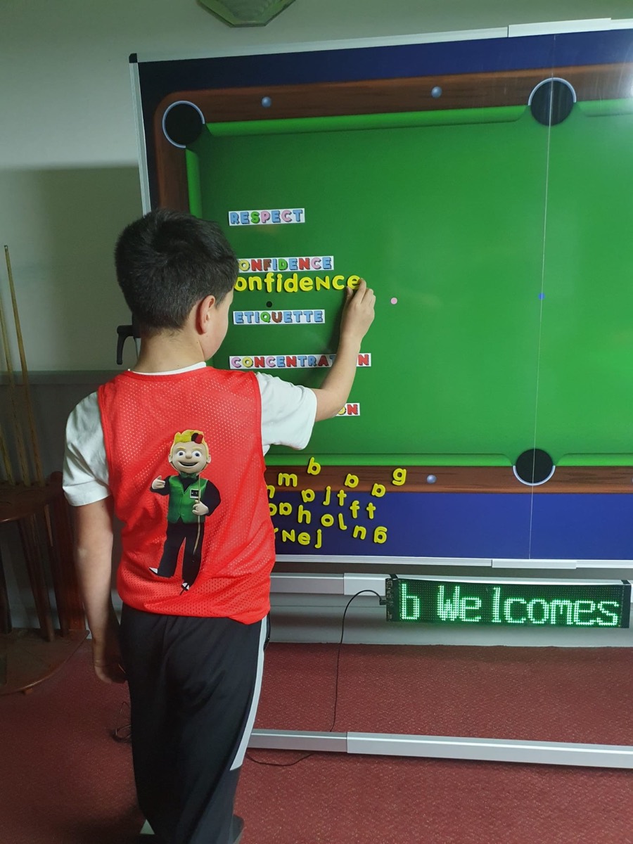 A pupil adding the word confidence to the learning board