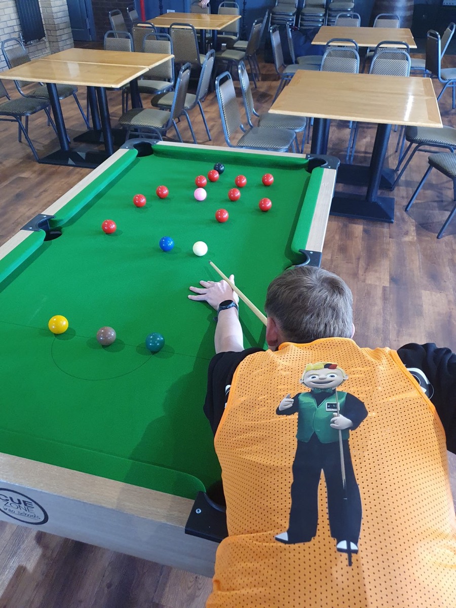 A player in an ACE bib lining up a shot